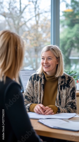 A social worker listens attentively to a client, providing guidance in a bright and welcoming office. The atmosphere is warm, fostering open communication