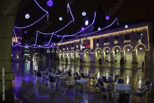 Plaza mojada adornada de Navidad por la noche
