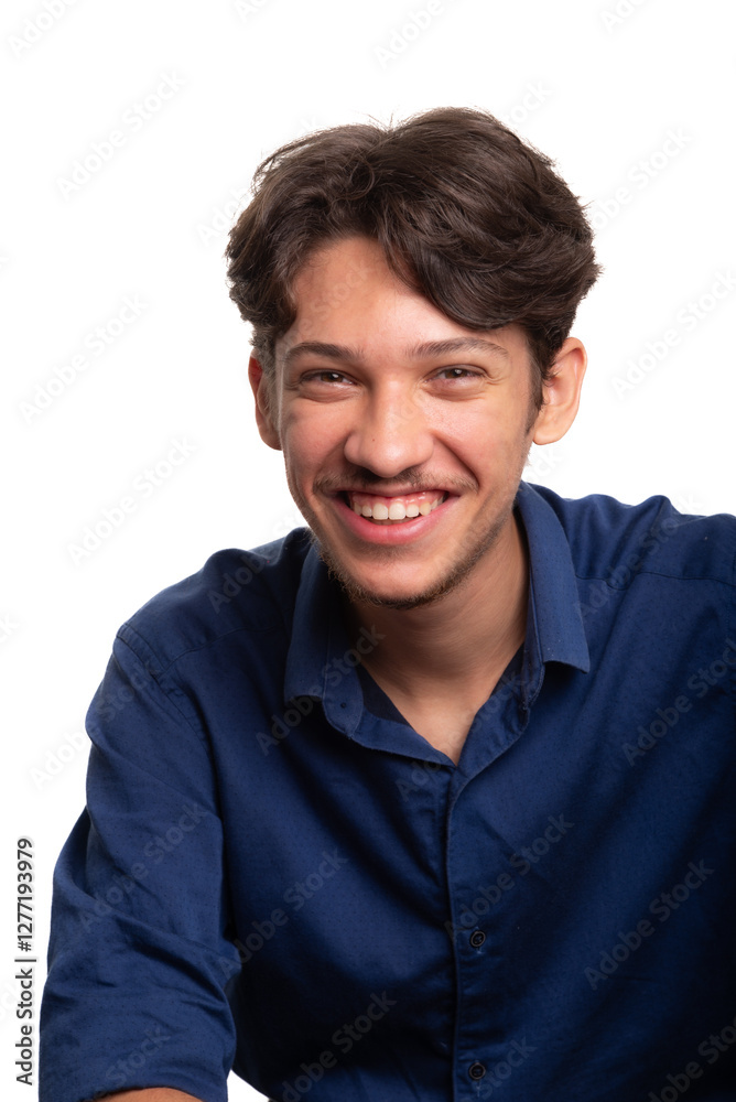 Young handsome student with black hair and blue shirt, sitting and smiling, looking at camera. Isolated on white background. Confident person. Young handsome student with black hair and blue shirt, sitting and smiling, looking at camera. Isolated on white background. Confident person.