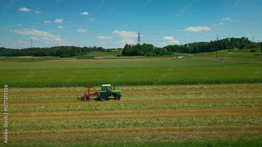 Combine with rotating rakes working in green fields at summer. Vertical video Combine with rotating rakes working in green fields at summer. Vertical video