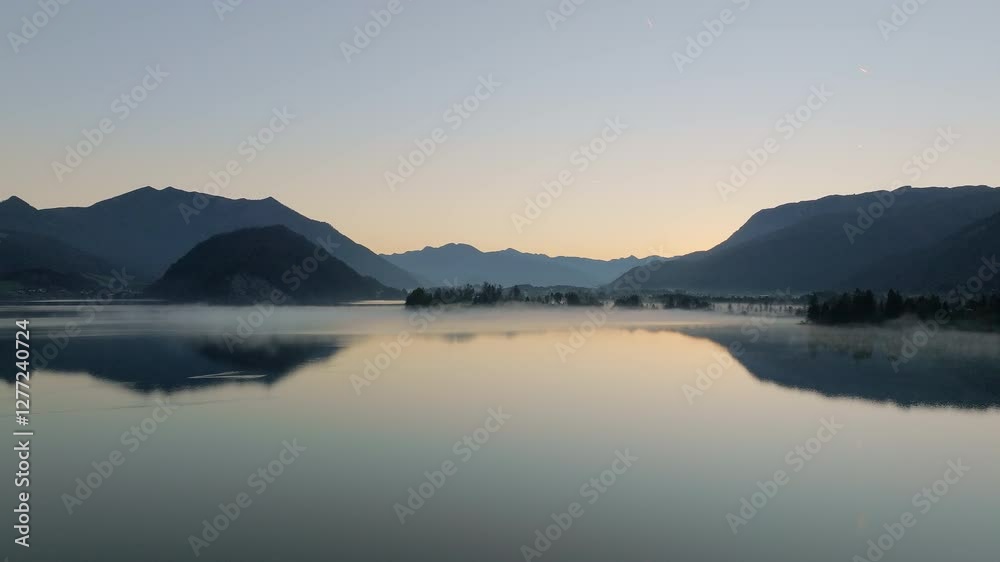 Serene Alpine Lake With Morning Mist And Silhouetted Peaks Serene Alpine Lake With Morning Mist And Silhouetted Peaks