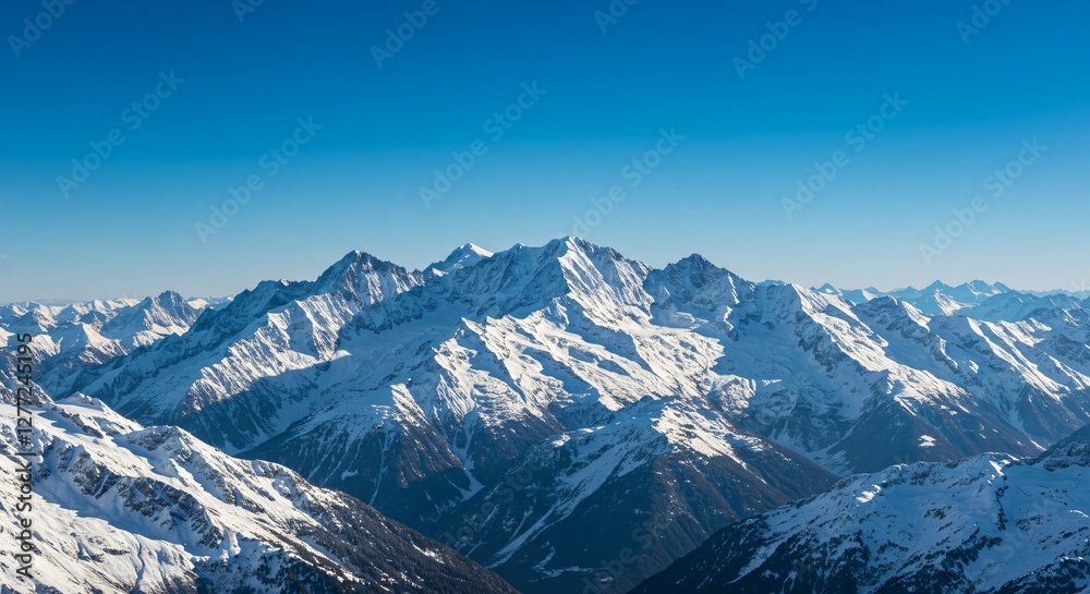 Fototapeta premium Majestic mountain range with snow-capped peaks and clear blue sky