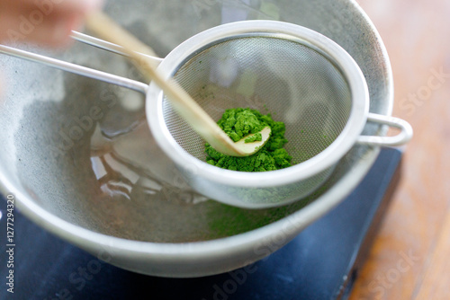Closeup of fresh matcha powder, green tea powder, Chashaku, matcha scoop and Chawan, matcha bowl.