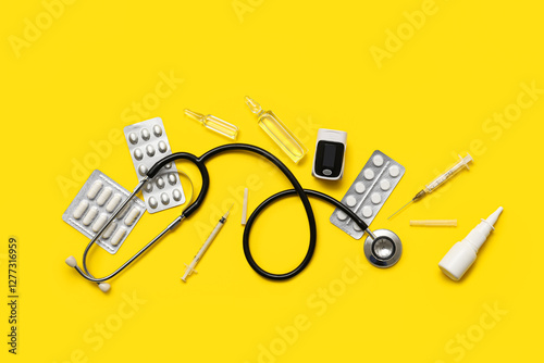 Composition with pulse oximeter, stethoscope and medicines on yellow background photo