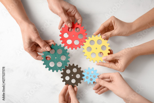 Hands holding wooden gears ...