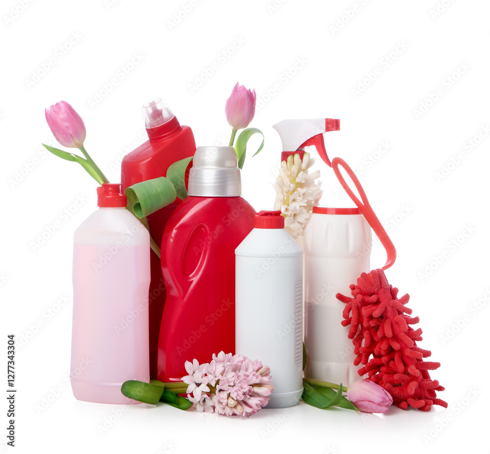 Bottles of detergents with duster and spring flowers on white background Bottles of detergents with duster and spring flowers on white background