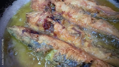 catfish being fried in boiling oil looks so delicious