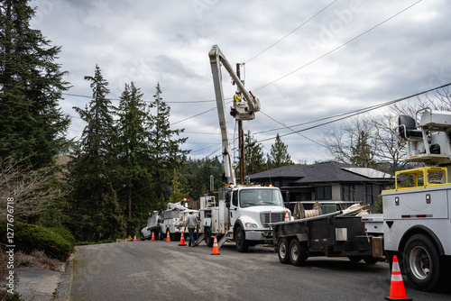 Foto Heavy duty utility company hydraulic bucket lift trucks with line crew working o