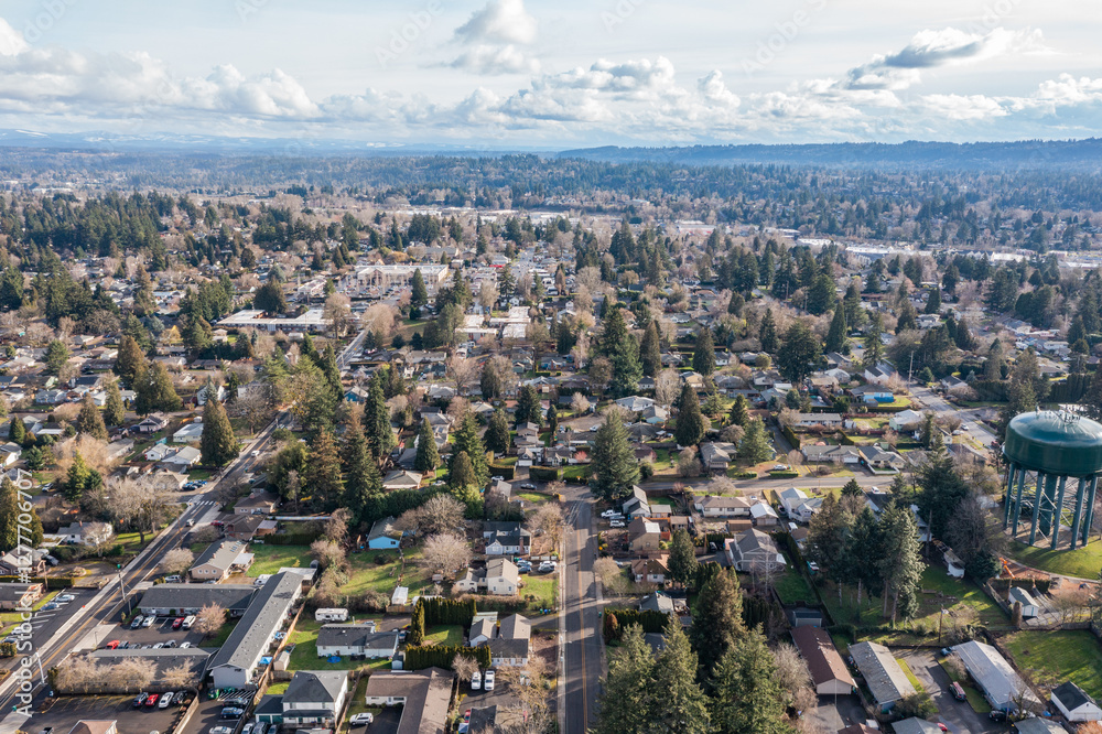 Fototapeta premium Aerial drone view of Milwaukie, OR, showcasing residential neighborhoods, tree-lined streets, and urban landscape along the Willamette River, with views of parks, commercial areas, and suburban homes