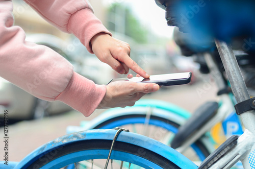 People use smart phone to scan the QR code on a shared bike to unlock it.