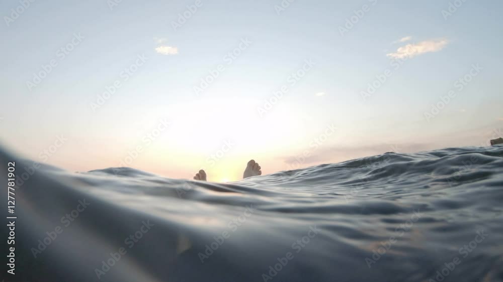 Swimming floating POV underwater looking at sunset over ocean water Swimming floating POV underwater looking at sunset over ocean water