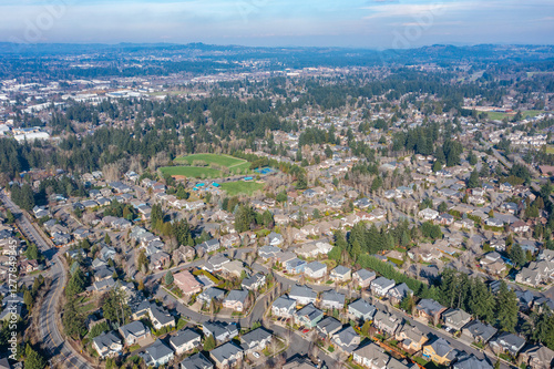 Aerial drone view of Tualatin, OR, showcasing an expansive residential neighborhood with tree-lined streets, suburban homes, parks, and green spaces, highlighting the area's planned community layout photo