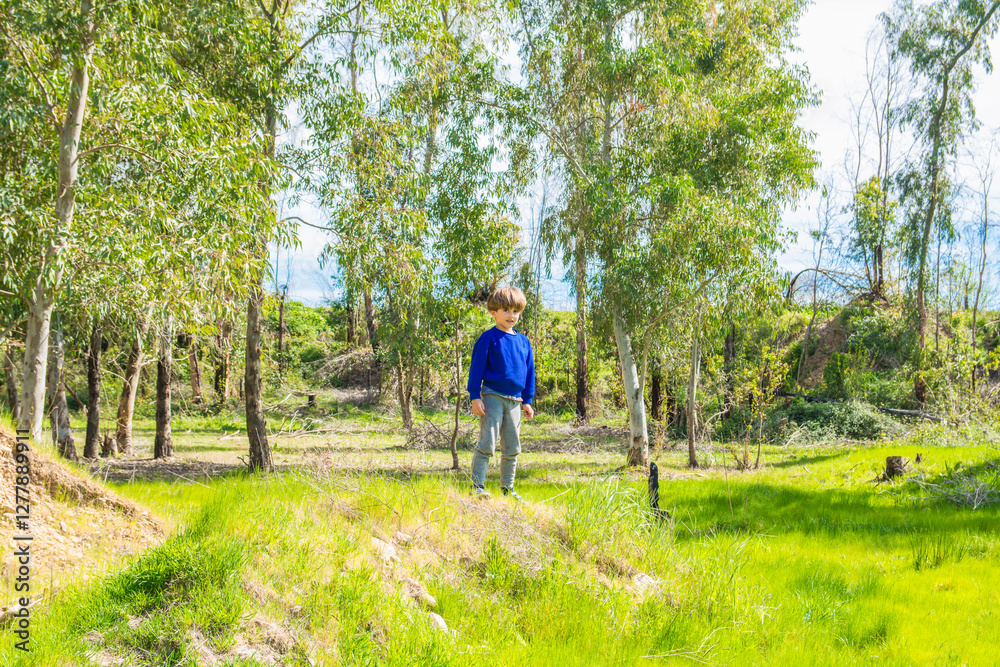 Happy child enjoying a sunny spring day in a lush green forest, fostering a connection with nature and creating cherished childhood memories Happy child enjoying a sunny spring day in a lush green forest, fostering a connection with nature and creating cherished childhood memories