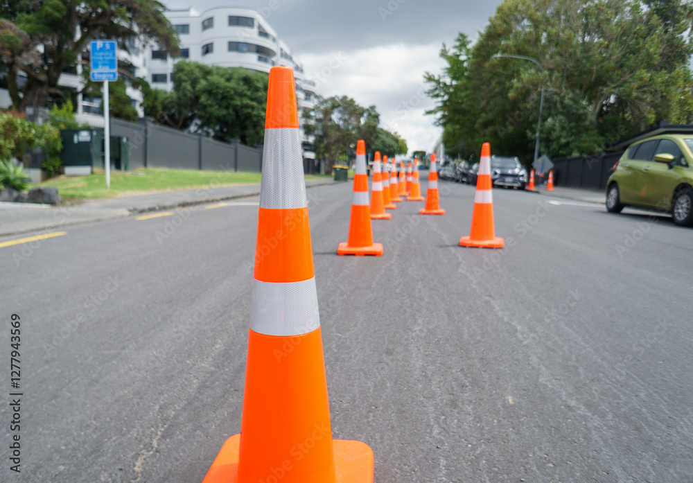 Orange traffic cones lining up the street. Roadworks in Auckland.