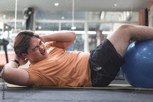 Exhausted overweight man exercising at gym overcoming tiredness fitness journey indoor motivational
