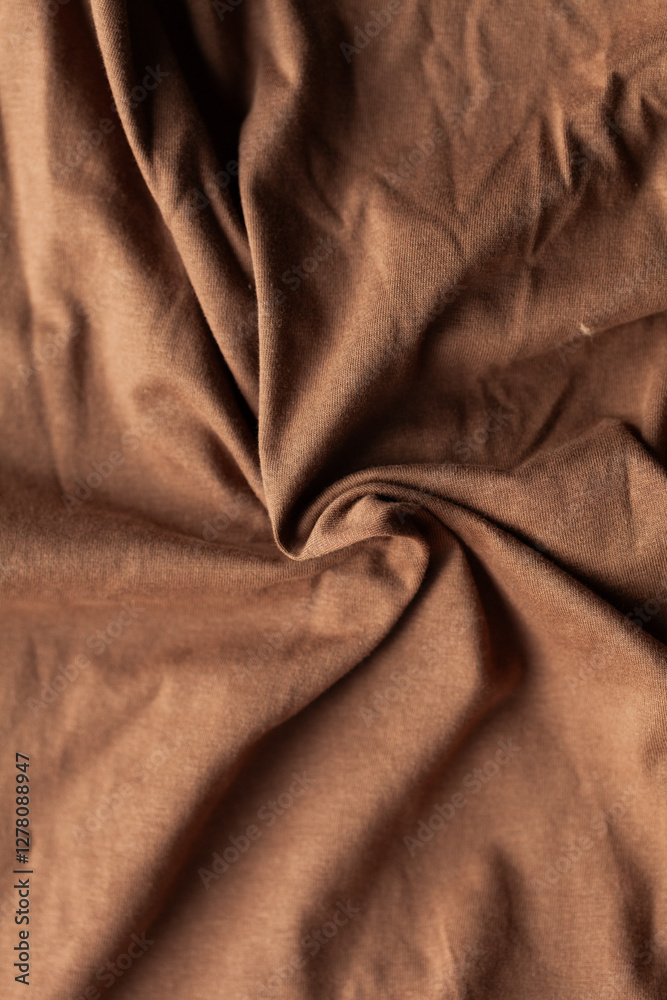 Obraz premium Close-up of soft brown fabric with elegant folds and textures, ideal for backgrounds or textile-related designs.