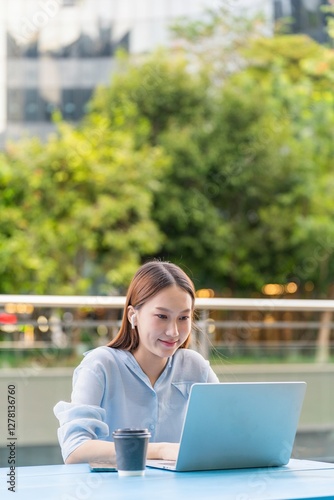 Young Asian Woman Listening Music while Working on Laptop Outdoors Free Download Young Asian Woman Listening Music while Working on Laptop Outdoors - GFXLoad