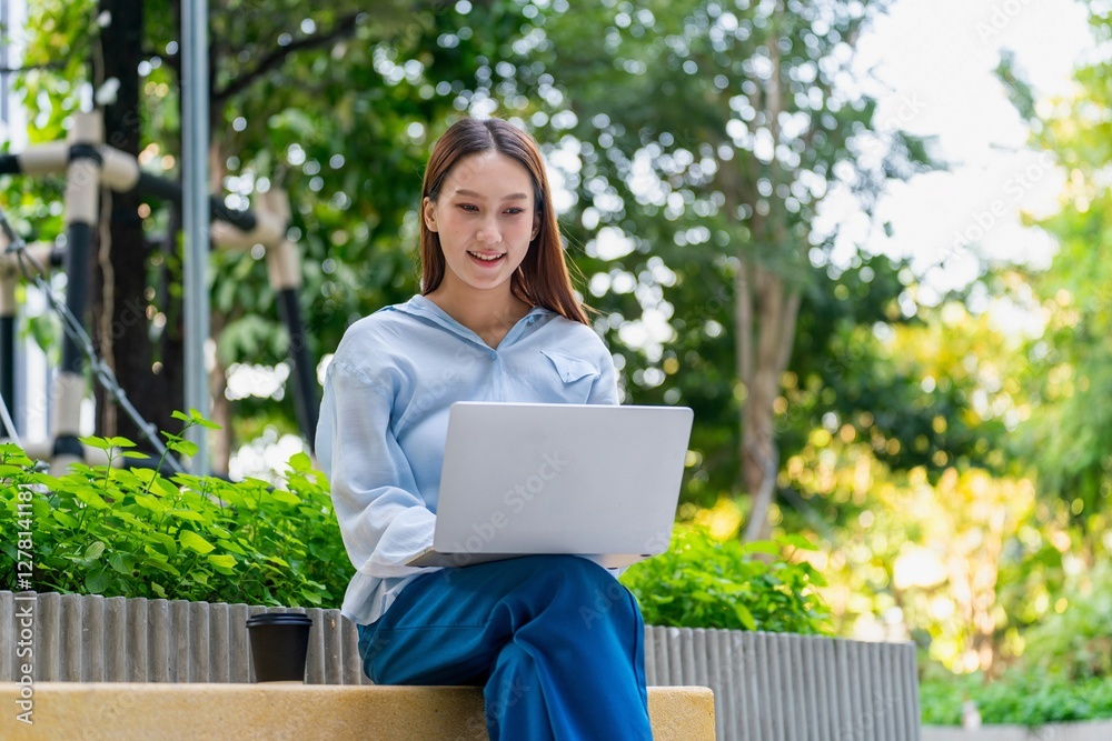 Young Asian Woman Using Laptop While Taking a Coffee Break Outdoors a Modern Urban Greenery Office Settings Young Asian Woman Using Laptop While Taking a Coffee Break Outdoors a Modern Urban Greenery Office Settings