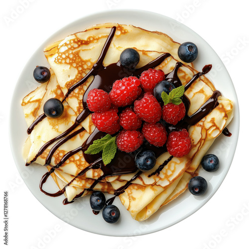 A plate of golden crepes drizzled with rich chocolate sauce and topped with fresh raspberries, blueberries, and a sprig of mint, isolated on a transparent background.