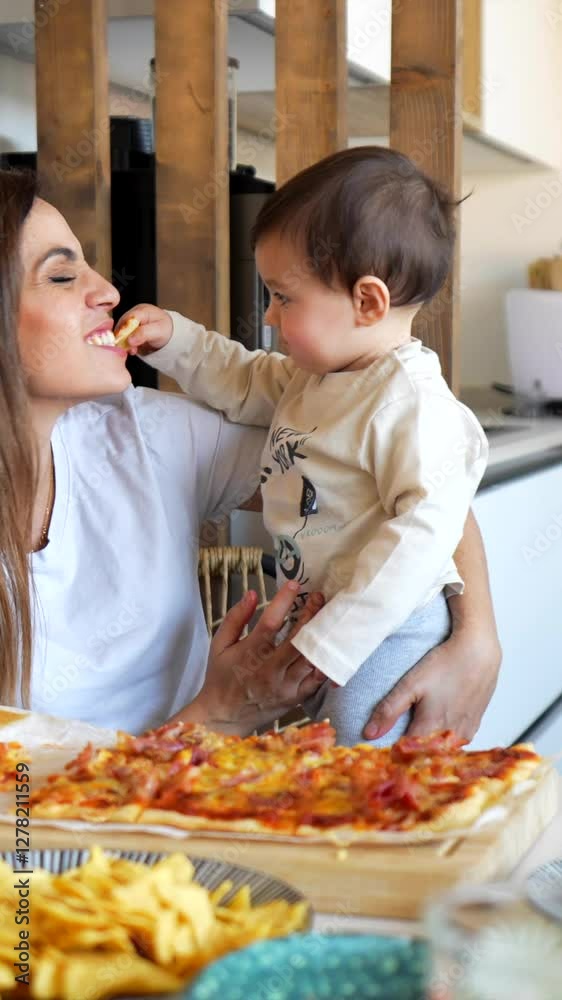 Caring toddler lovingly sharing pizza slice with mother, creating heartwarming moment of connection inside bright kitchen during family mealtime Caring toddler lovingly sharing pizza slice with mother, creating heartwarming moment of connection inside bright kitchen during family mealtime