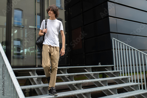 Wallpaper Mural Young tall caucasian guy in white tshirt on the steps at the building entrance Torontodigital.ca