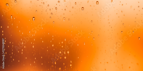 Close-up of raindrops on window with blurred orange background, creating a tranquil ambiance.