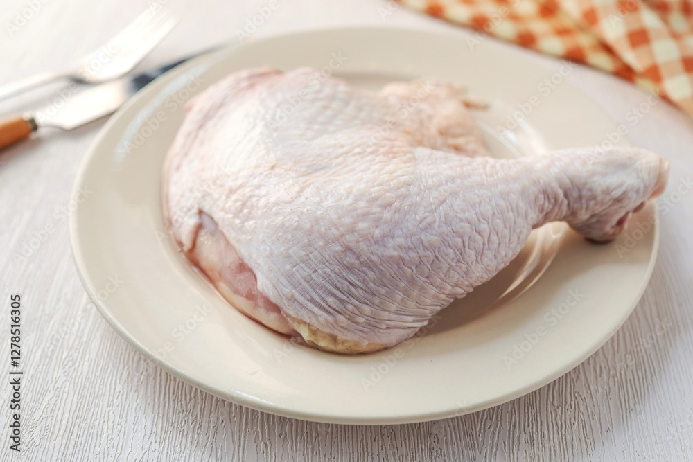Fresh chicken thigh, raw chicken thigh ,chicken leg in ceramic plate on white background Fresh chicken thigh, raw chicken thigh ,chicken leg in ceramic plate on white background