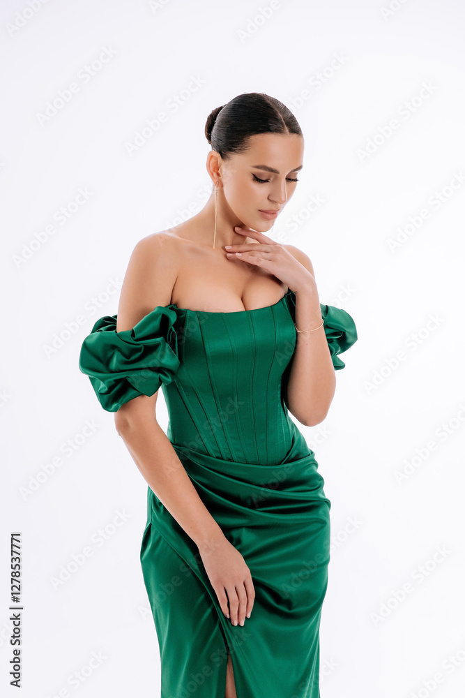 Beautiful brunette girl in a green and emerald evening dress on a white background isolated Beautiful brunette girl in a green and emerald evening dress on a white background isolated