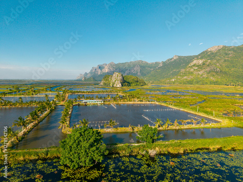 Aerial view of fish farming pond in scenic thai landscape with mountains and lush greenery