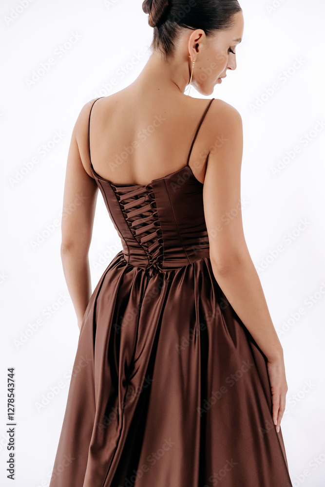 Tall brunette with hairstyle in dark brown luxurious fashionable dress with train isolated on white background Tall brunette with hairstyle in dark brown luxurious fashionable dress with train isolated on white background