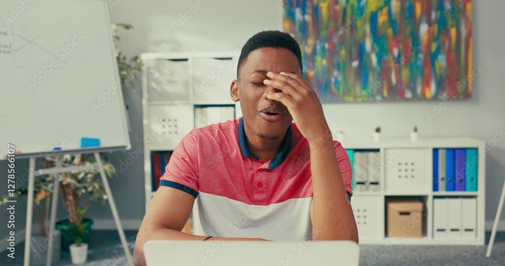 Fototapeta premium Handsome man working for large company sits in office in front of laptop talks to co-worker on video conference webcam they discuss about project guy breaks down amount of work gestures he will call