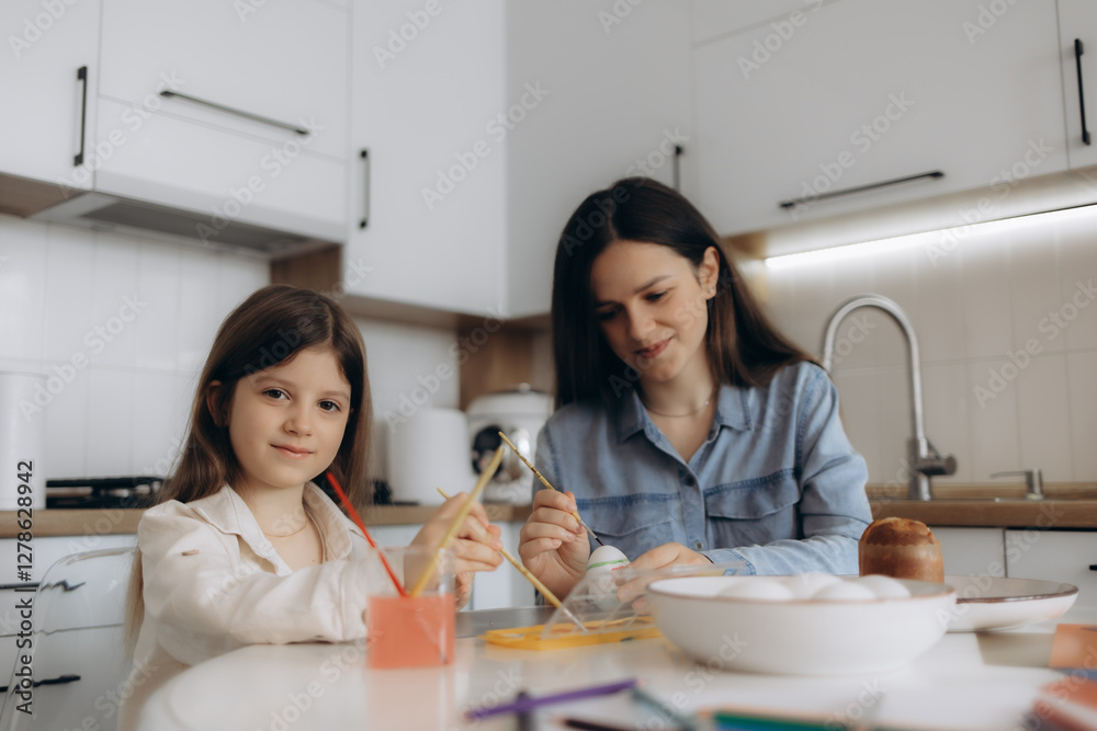Mother and Daughter Painting Eggs Together in a Bright Kitchen Mother and Daughter Painting Eggs Together in a Bright Kitchen