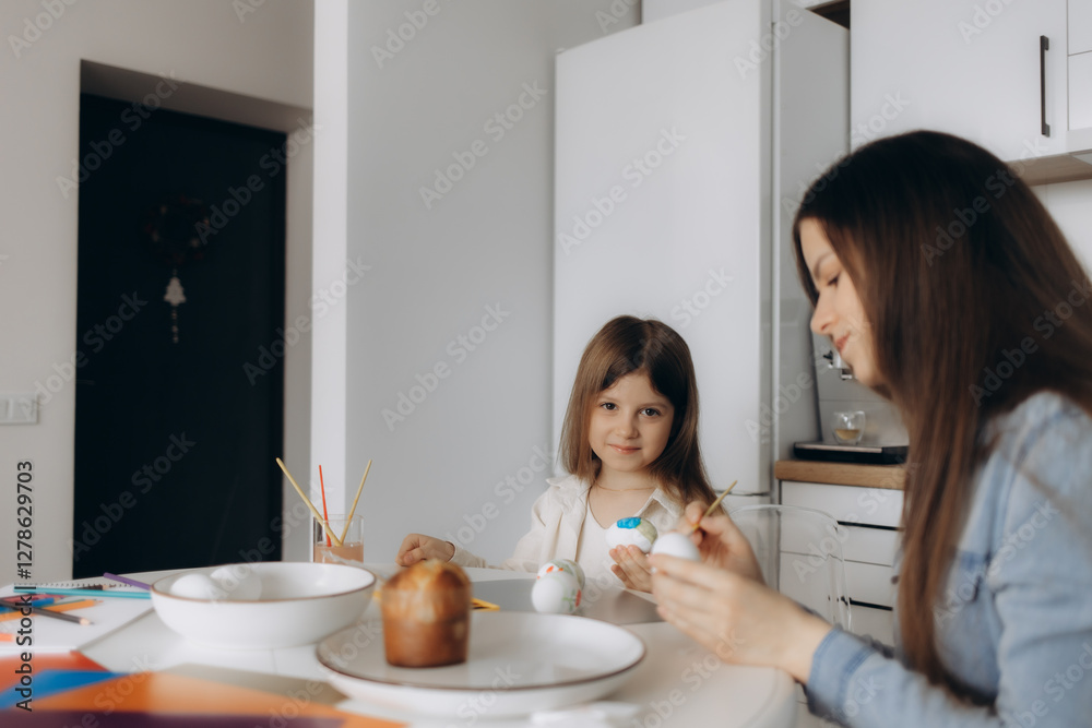 Mother and Daughter Painting Eggs in a Bright Kitchen Mother and Daughter Painting Eggs in a Bright Kitchen