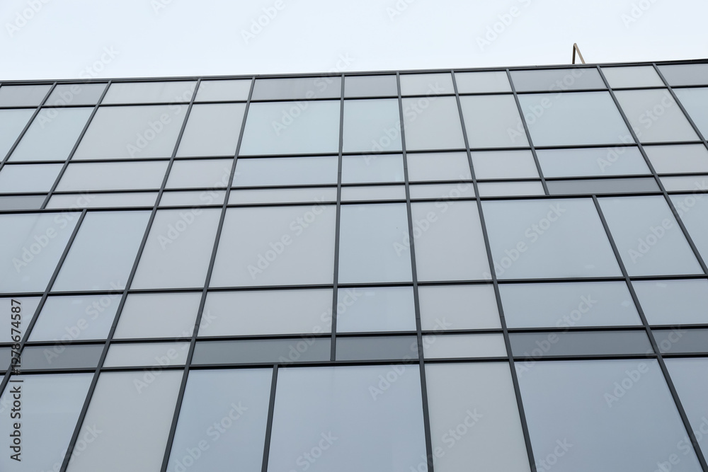 Modern building with many windows against blue sky, low angle view Modern building with many windows against blue sky, low angle view