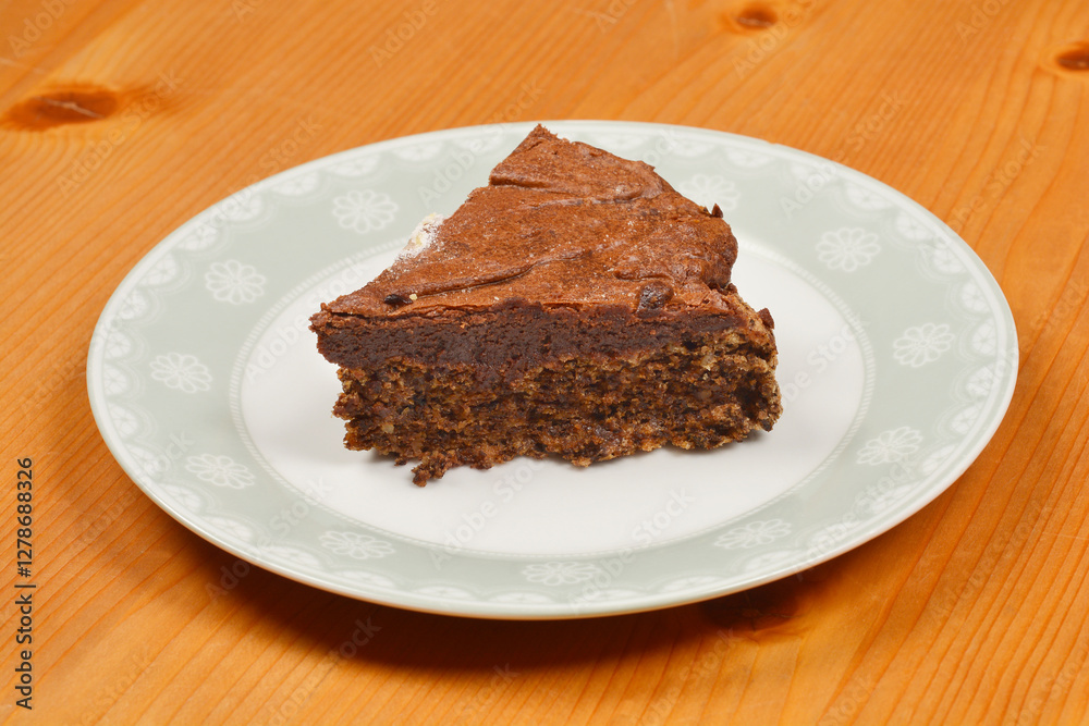 A side view of slice of homemade chocolate cake presented on a decorative plate A side view of slice of homemade chocolate cake presented on a decorative plate