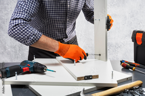 Wallpaper Mural  Worker assembles shelf. Man assembly furniture. Torontodigital.ca