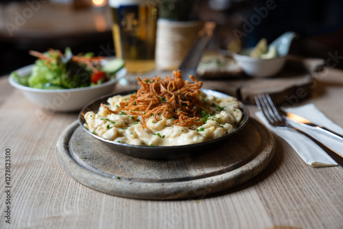 Deftige Käsespätzle mit Röstzwiebeln und Bier im Wirtshaus

