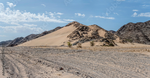 Obraz na płótnie rocky basalt slope covered with sand, near De Riet, Namibia w salonie