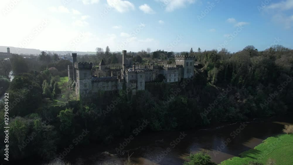 Aerial view of Lismore Castle, Ireland, showcasing its stunning Gothic architecture and scenic riverside location Aerial view of Lismore Castle, Ireland, showcasing its stunning Gothic architecture and scenic riverside location
