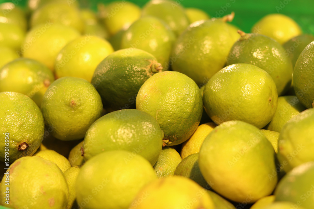 Limes close-up with selective focus. Heaps of tasty limes for sale in a store. Variety of fresh produce. Ripe limes for sale in a supermarket. Ripe, juicy, green fruits with vitamin C. Limes close-up with selective focus. Heaps of tasty limes for sale in a store. Variety of fresh produce. Ripe limes for sale in a supermarket. Ripe, juicy, green fruits with vitamin C.