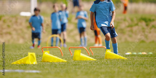 Football training camp for school kids. Children playing soccer training games outdoors. Kids running at obstacle course