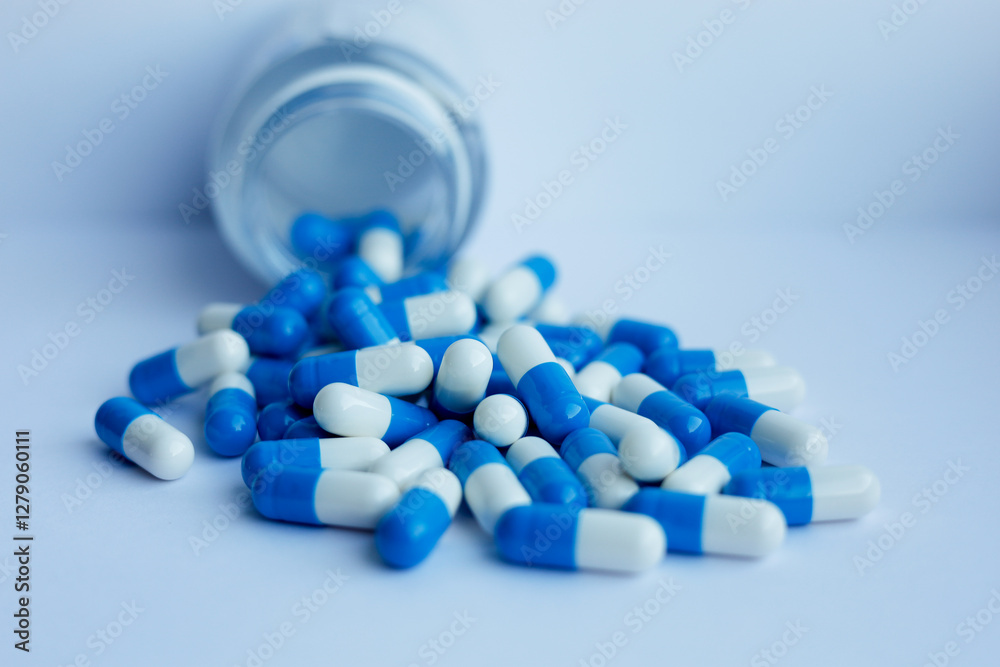 Blue and white capsules fall out of the bottle Blue and white capsules fall out of the bottle