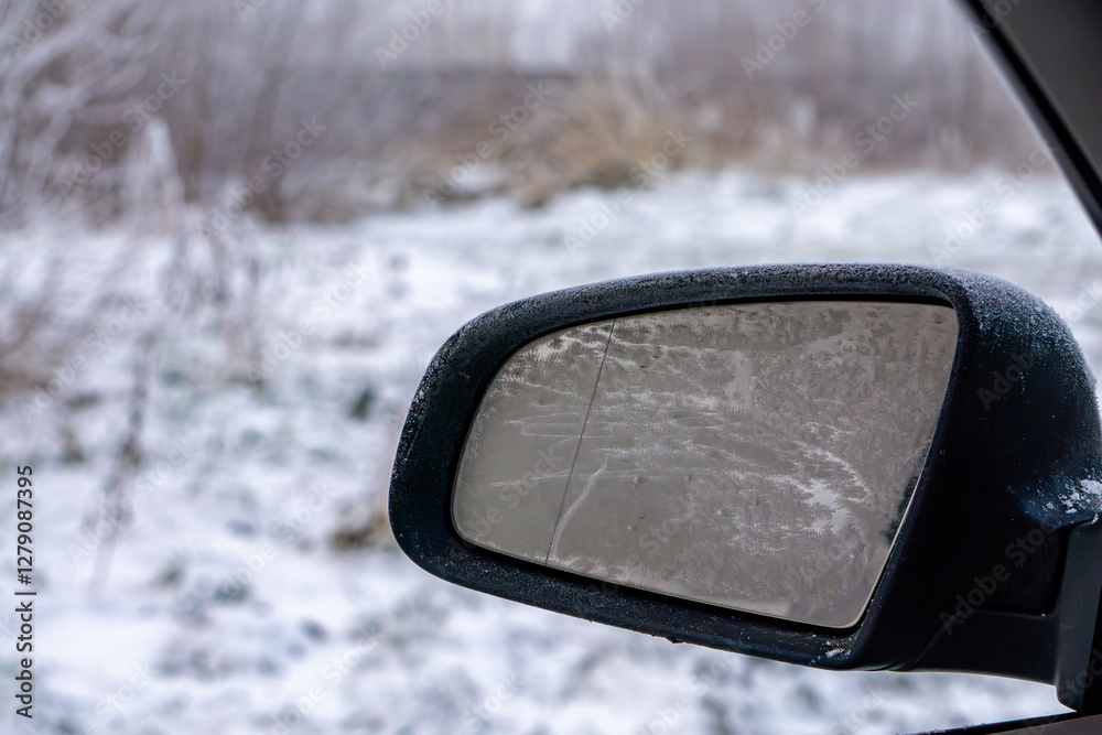 frozen side mirror on a passenger car on a frosty winter morning. mirror requiring scraping and cleaning. frozen side mirror on a passenger car on a frosty winter morning. mirror requiring scraping and cleaning.