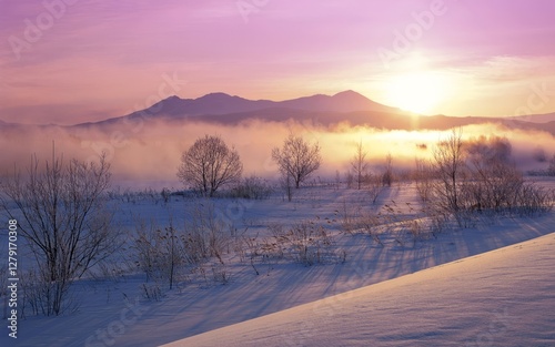 Frozen mountain scenes transition from white sunrise to cold sunset, with a snowy river landscape and frosted trees photo