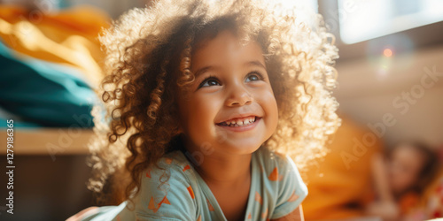 Obraz na płótnie Smiling curly haired child in a cozy room, looking up with joy w salonie