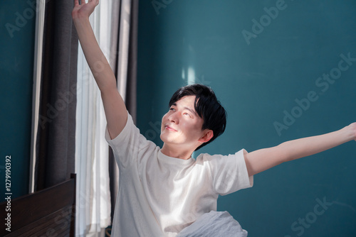 Canvastavla 朝日が差し込む中で爽やかに目覚める若い男性