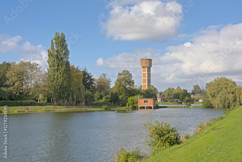 Fish pond and brickt stone watertower in a park in the city of Melle, Flanders, Belgium 