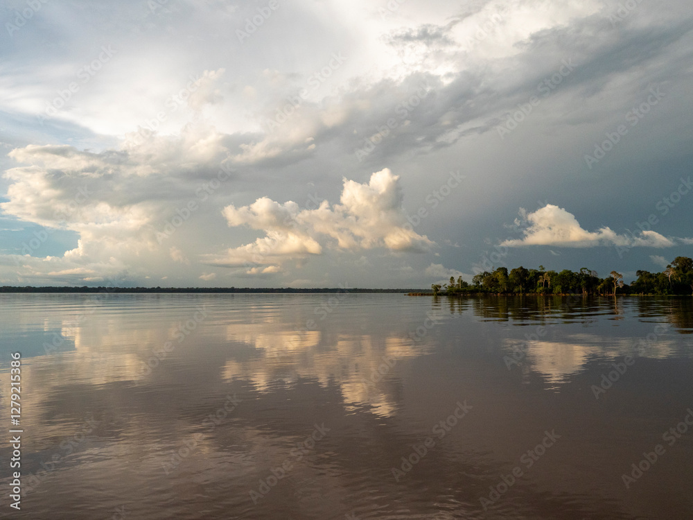 Obraz premium Amazon river landscape. Clouds are reflected on the huge expanse of water in the Amazon.