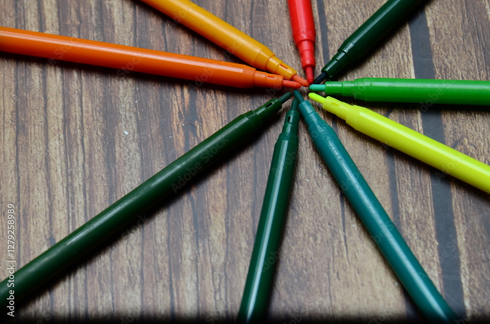 Fototapeta premium A macro shot of an assortment of different colored crayons stacked together isolated on a wooden background.