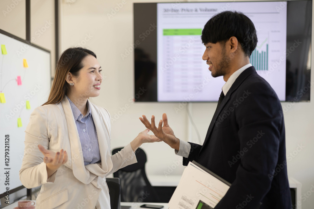 Two people in suits are looking at a presentation on a computer screen. One of them is pointing at the screen
Two people in suits are looking at a presentation on a computer screen. One of them is pointing at the screen